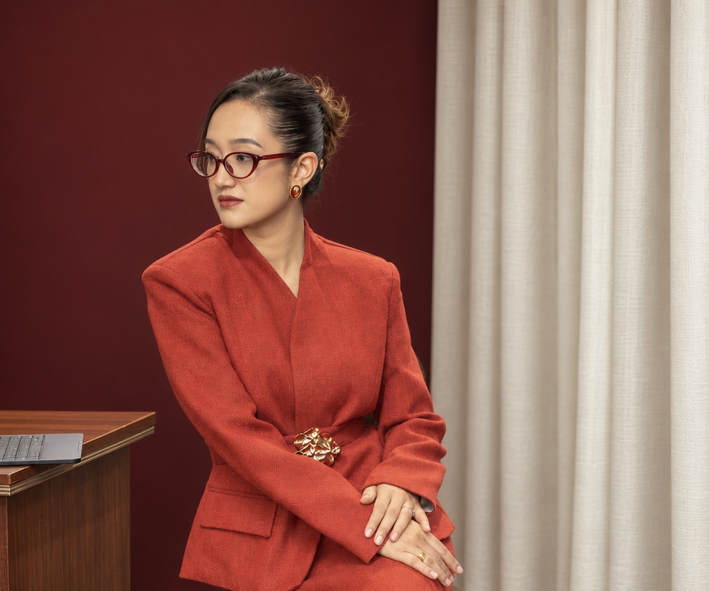 Shrija Shrestha seated by a curtain, looking to the side